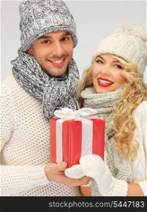 picture of romantic couple in a sweaters with gift box