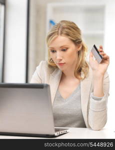 picture of serious woman with laptop computer and credit card.