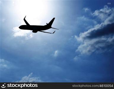 Picture of silhouette airplane in blue sky, journey trip, airliner in heaven, plane over clouds background, air transportation, luxury airline, business destination, fast flight, tourism concept