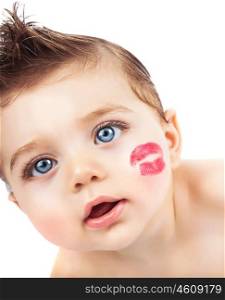Picture of small pretty kid with red lipstick kiss on the cheek, closeup portrait of cute baby boy isolated on white background, curious toddler with open mouth looking in the camera, Valentines day