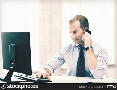 picture of smiling businessman with smartphone in office