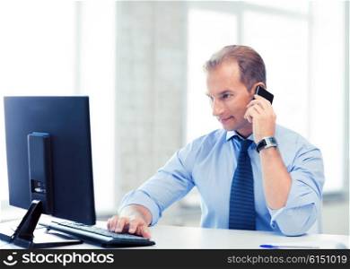 picture of smiling businessman with smartphone in office. smiling businessman with smartphone in office