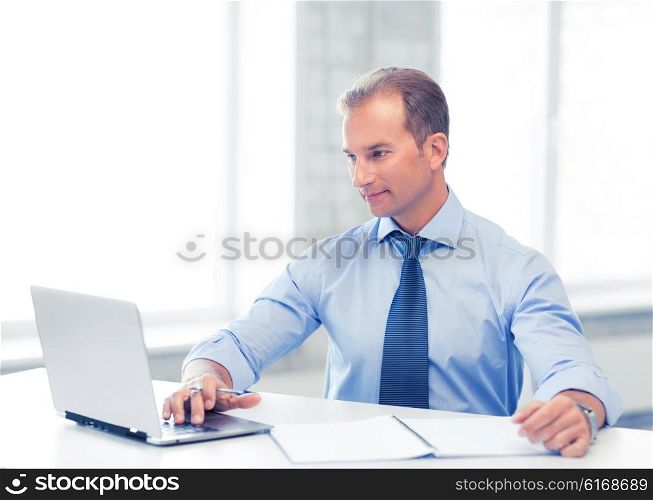 picture of smiling businessman working in office. miling businessman working in office