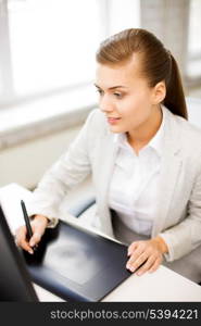 picture of smiling businesswoman with drawing tablet in office