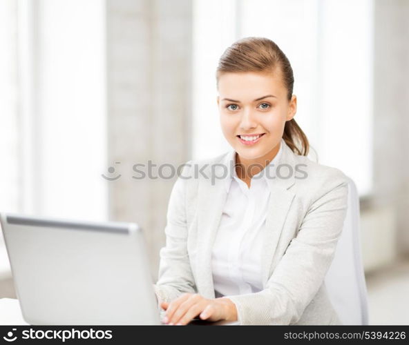 picture of smiling businesswoman with laptop in office