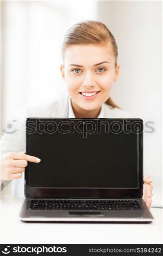 picture of smiling businesswoman with laptop in office