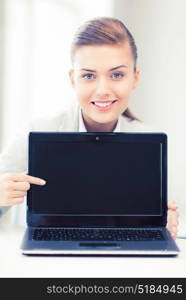 picture of smiling businesswoman with laptop in office. businesswoman with laptop in office