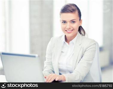 picture of smiling businesswoman with laptop in office. businesswoman with laptop in office