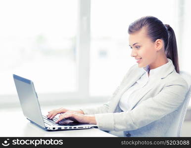 picture of smiling businesswoman with laptop in office. businesswoman with laptop in office