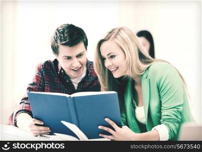 picture of smiling student girl and guy reading book at school