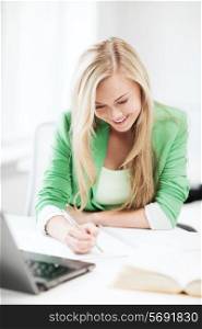 picture of smiling student girl writing in notebook