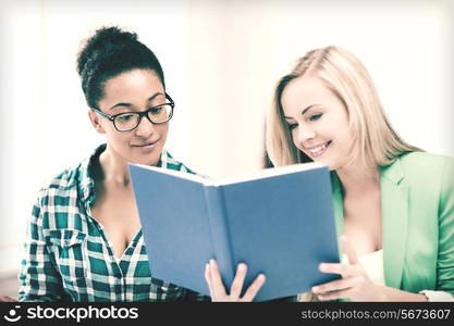 picture of smiling student girls reading book at school