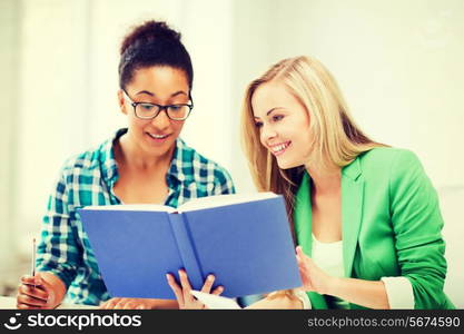 picture of smiling student girls reading book at school