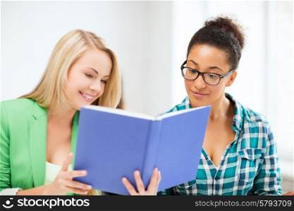 picture of smiling student girls reading book at school