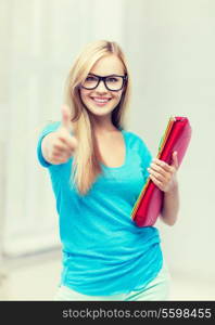 picture of smiling student with folders showing thumbs up