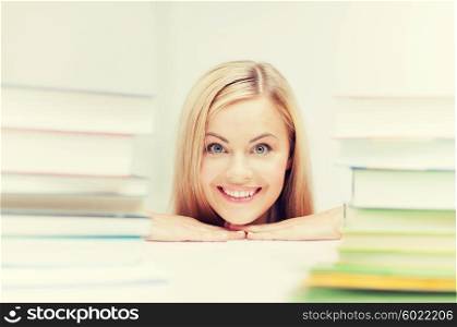 picture of smiling student with stack of books. student with stack of books