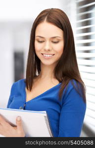 picture of smiling young businesswoman taking notes