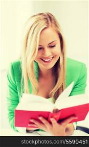 picture of smiling young woman reading book at school