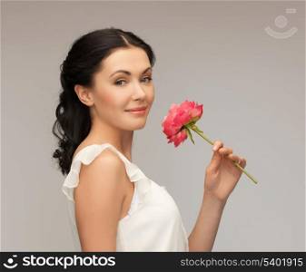 picture of smiling young woman smelling flower