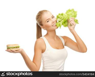 picture of sporty woman with green lettuce and hamburger