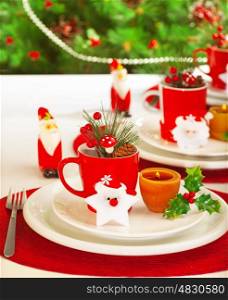 Picture of table setting for winter holidays time, holiday banquet, Christmas celebration, luxury white porcelain dishware on red festive tablecloth, New Year party, decorated evergreen tree