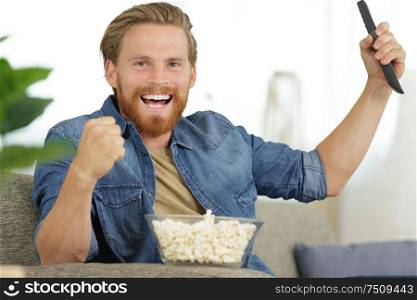 picture of triumphant male holding remote