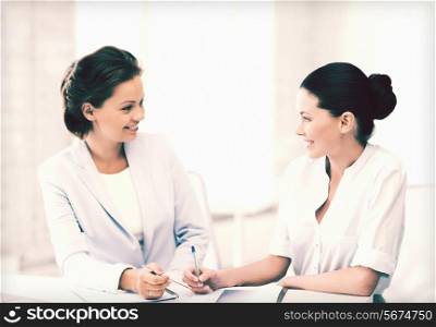 picture of two businesswomen having discussion in office