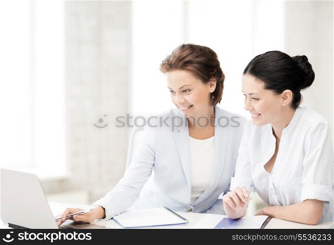 picture of two businesswomen working with laptop in office