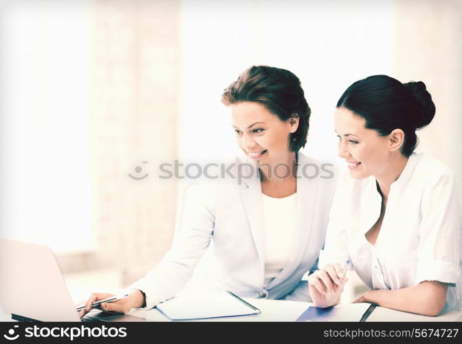 picture of two businesswomen working with laptop in office