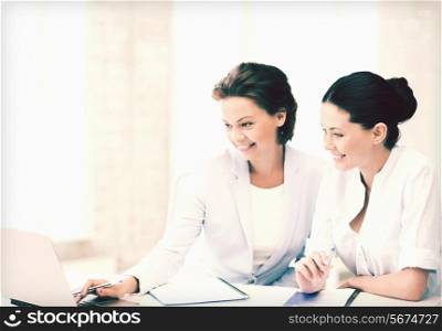 picture of two businesswomen working with laptop in office