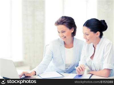 picture of two businesswomen working with laptop in office. businesswomen working with laptop in office