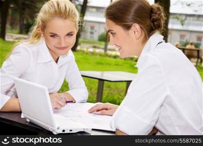 picture of two happy businesswomen with documents and laptop