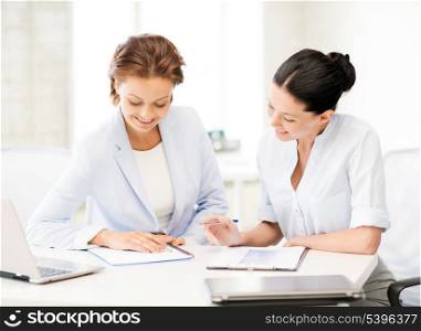 picture of two smiling businesswomen working in office