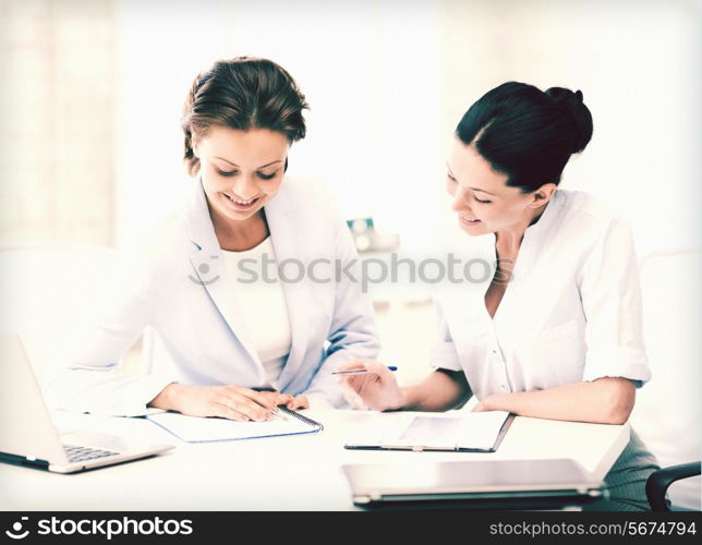 picture of two smiling businesswomen working in office