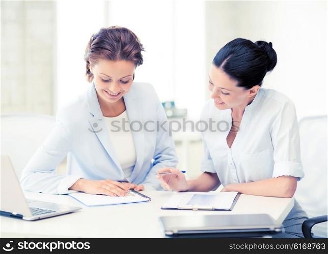 picture of two smiling businesswomen working in office. two smiling businesswomen working in office