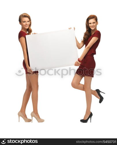 picture of two teenage girls in red dresses with blank board