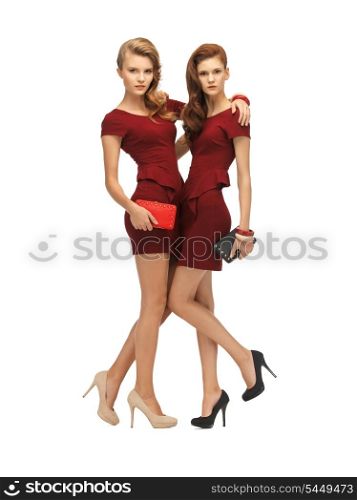 picture of two teenage girls in red dresses with clutches