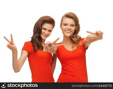 picture of two teenage girls in red t-shirts showing victory sign