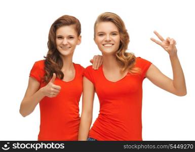 picture of two teenage girls showing thumbs up and victory sign
