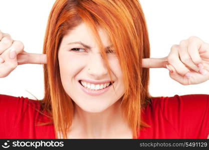 picture of unhappy redhead woman with fingers in ears