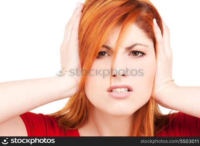 picture of unhappy redhead woman with hands on ears