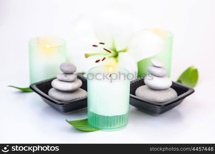 Picture of white lily flower, candles, pebble stones isolated on white background, beauty salon, luxury spa resort, alternative treatment, zen balance, aroma therapy, wellness and wellbeing concept