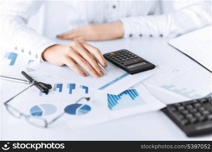 picture of woman hand with calculator and papers