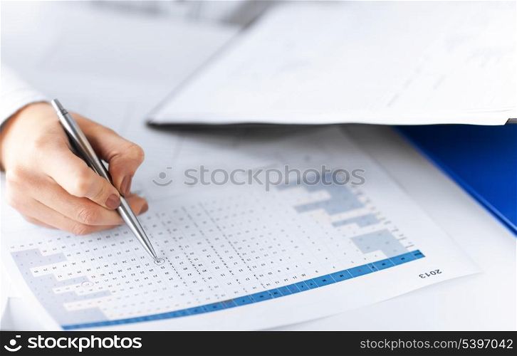 picture of woman hand wrtiting on paper with numbers