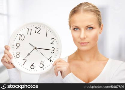 picture of woman holding big clock in office
