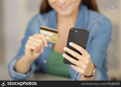 picture of woman holding cellphone and credit card