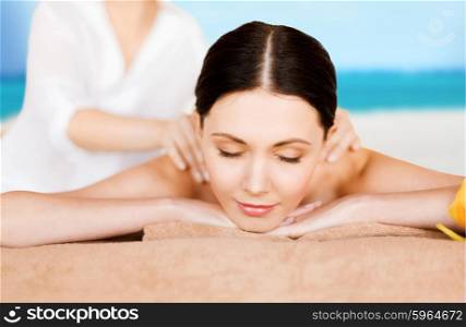 picture of woman in spa salon getting massage on the beach. woman in spa