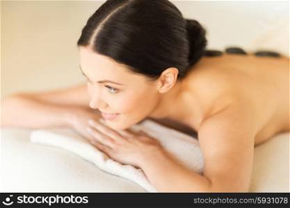 picture of woman in spa salon with hot stones. woman in spa with hot stones