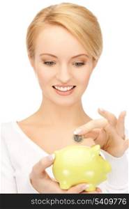 picture of woman putting coin into small piggy bank
