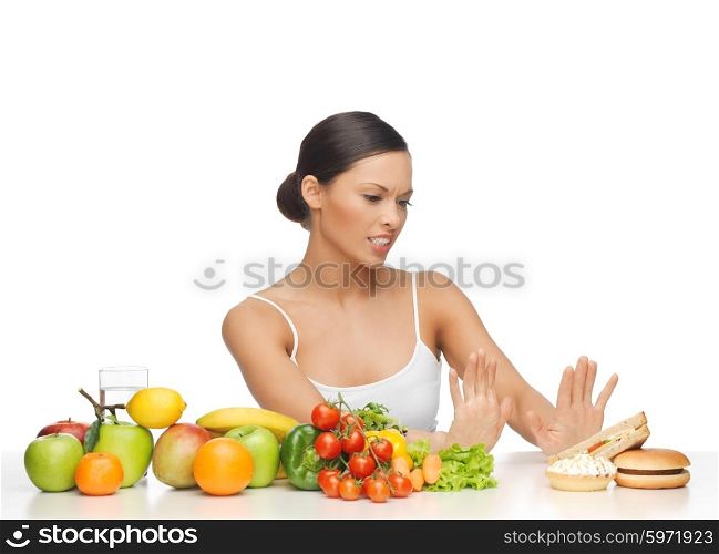 picture of woman with fruits rejecting hamburger. woman with fruits rejecting hamburger